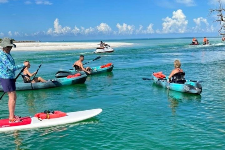 a group of people riding on the back of a boat in the water