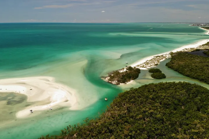 a sandy beach next to a body of water