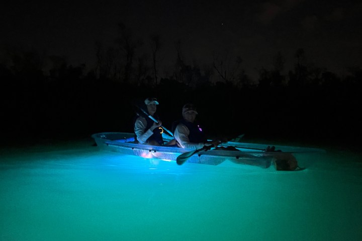 a man riding on the back of a boat in the water