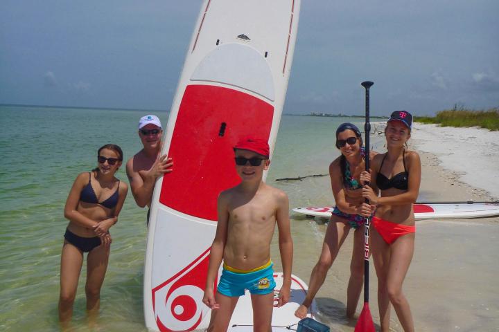 a group of people standing next to a body of water